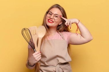 Genç ve güzel bir kadın. Düşünen ya da şüphe eden ifade şefi aşçılık konsepti
