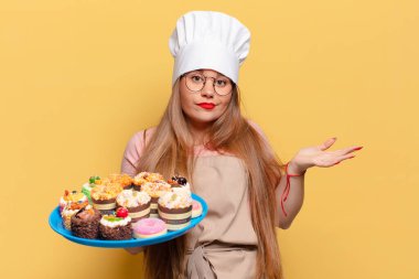 Genç ve güzel bir kadının kafası karışık fırıncı yemek pişirme konsepti