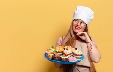 Genç ve güzel bir kadın. Düşünen ya da şüphe duyan fırıncı yemek pişirme konsepti