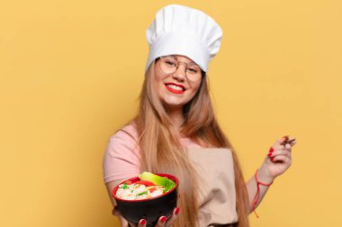 Genç ve güzel bir kadın. Mutlu ve şaşırmış bir ifade. Şef erişte pişirme konsepti