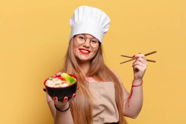 Genç ve güzel bir kadın. Mutlu ve şaşırmış bir ifade. Şef erişte pişirme konsepti