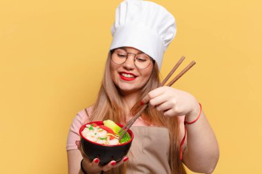 Genç ve güzel bir kadın. Mutlu ve şaşırmış bir ifade. Şef erişte pişirme konsepti