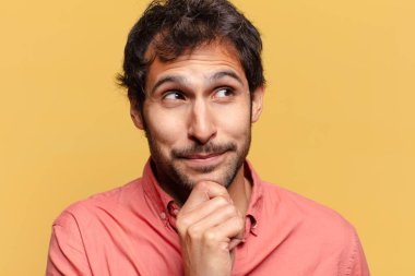 Genç, yakışıklı Hintli adam. Düşünen ya da kuşkulu ifade