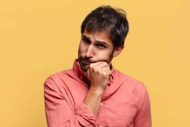 Genç, yakışıklı Hintli adam. Düşünen ya da kuşkulu ifade