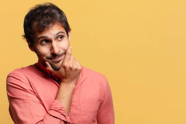 Genç, yakışıklı Hintli adam. Düşünen ya da kuşkulu ifade