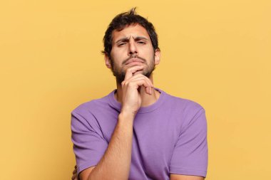 Genç, yakışıklı Hintli adam. Düşünen ya da kuşkulu ifade