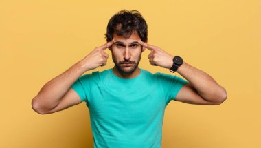 Genç, yakışıklı Hintli adam. Düşünen ya da kuşkulu ifade