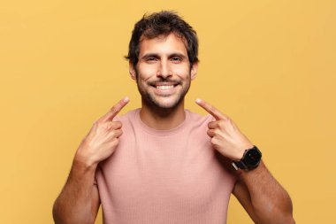 Genç, yakışıklı Hintli adam. Mutlu ve şaşırmış ifade