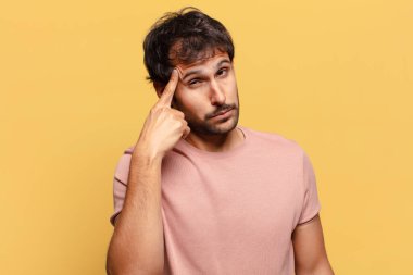 Genç, yakışıklı Hintli adam. Düşünen ya da kuşkulu ifade