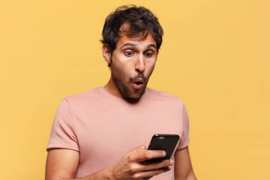 Genç, yakışıklı Hintli adamın kafası karışmış akıllı telefon konsepti