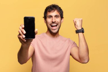Genç ve yakışıklı Hintli adam kutlama ve gururlu ifade akıllı telefon kavramı