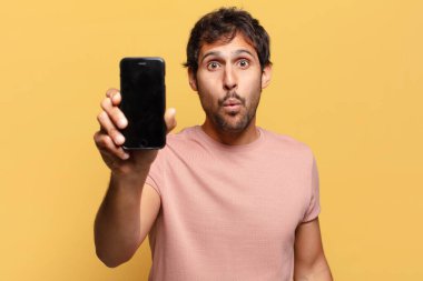 Genç, yakışıklı Hintli adam. şok ya da şaşırmış ifade akıllı telefon kavramı