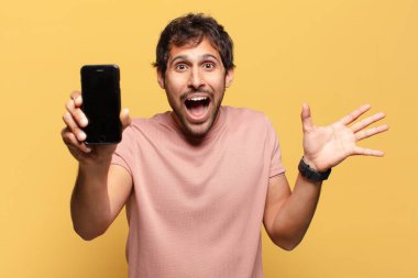 Genç ve yakışıklı Hintli adam kutlama ve gururlu ifade akıllı telefon kavramı