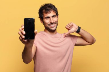 Genç yakışıklı Hintli adam gururlu ifade akıllı telefon kavramı