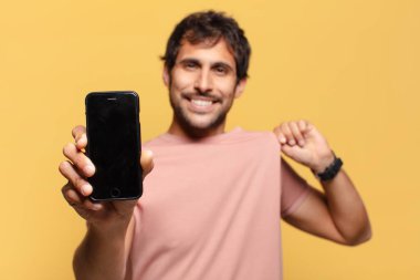 Genç yakışıklı Hintli adam gururlu ifade akıllı telefon kavramı