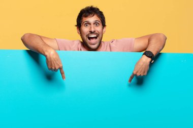 Genç, yakışıklı Hintli adam. İşaret işareti. Mutlu ve şaşırmış