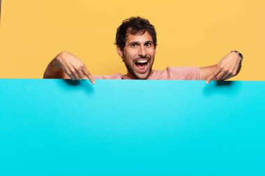 Genç, yakışıklı Hintli adam. İşaret işareti. Mutlu ve şaşırmış