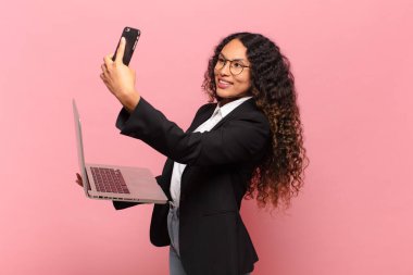 Genç, güzel, İspanyol bir kadın. Mutlu ve şaşırmış ifade işi ve dizüstü bilgisayar işlemcisi