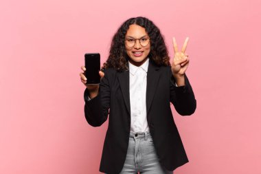 Genç ve güzel İspanyol kadın mutlu ve gururlu iş ve akıllı telefon kavramı