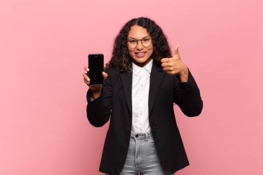 Genç, güzel, İspanyol bir kadın. Mutlu ve şaşırmış ifade işi ve akıllı telefon kavramı