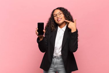 Genç, güzel, İspanyol bir kadın. Mutlu ve şaşırmış ifade işi ve akıllı telefon kavramı