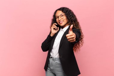 Genç, güzel, İspanyol bir kadın. Mutlu ve şaşırmış ifade işi ve akıllı telefon kavramı