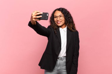 Genç, güzel, İspanyol bir kadın. Mutlu ve şaşırmış ifade işi ve akıllı telefon kavramı