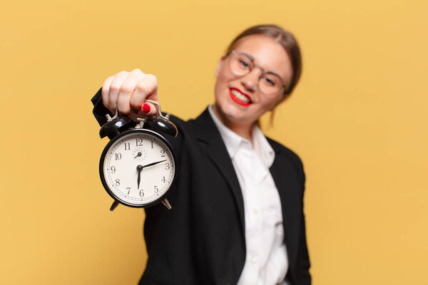молодая красивая женщина. счастливое и удивленное выражение лица. будильник
