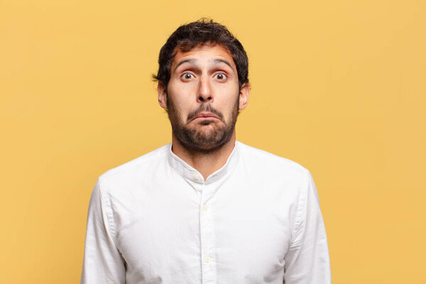 young handsome indian man scared and confused expression