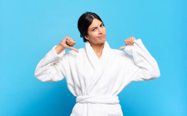 Genç İspanyol kadın üzgün, hayal kırıklığına uğramış ya da kızgın görünüyor. Anlaşmazlığa düşmüş, hayal kırıklığına uğramış hissediyor. Bornoz konsepti