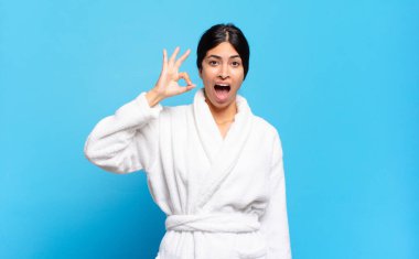 Genç İspanyol kadın kendini başarılı ve tatmin olmuş hissediyor, ağzı açık gülümsüyor, elle imza atıyor. Bornoz konsepti