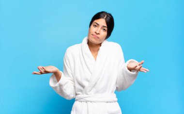 Genç İspanyol kadın şaşkın ve şaşkın hissediyor, doğru cevap ya da karardan emin değil, bir seçim yapmaya çalışıyor. Bornoz konsepti