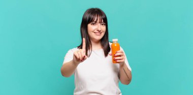 Gururla ve kendinden emin bir şekilde gülümseyerek bir numaralı pozu vererek, bir lider gibi hissederek.