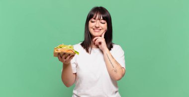 Gülümseyerek mutlu ve hayal kurarak ya da şüphe duyarak, yan tarafa bakarak