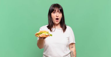 Şok olmuş ya da şaşırmış görünüyor, ağzı açık bakıyor ve 