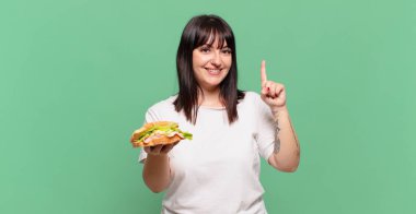 Gülümsüyor ve dost canlısı görünüyor, bir numara veya ilk eli önde, geriye doğru sayıyor.