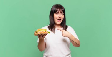 Heyecanlı ve şaşırmış görünüyor. Yana ve yukarıya bakıyor. Boşluğu kopyalıyor.