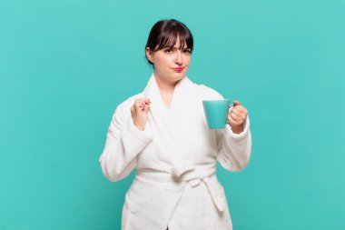 Bornoz giyen genç bir kadın kibirli, başarılı, pozitif ve gururlu görünüyor.