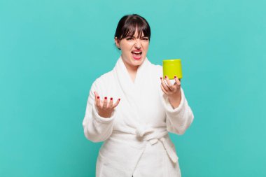 Bornoz giymiş genç bir kadın sinirli, sinirli ve sinirli görünüyor. Senin neyin var? 