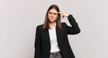 Genç iş kadını kafası karışık ve şaşkın hissediyor. Deli, deli ya da aklını kaçırmış olduğunu gösteriyor.