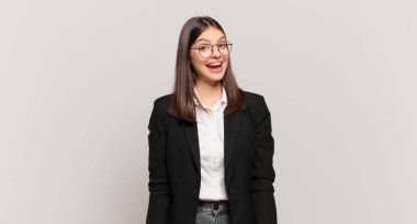 Büyük, dostane, kaygısız bir gülümsemesi olan genç bir iş kadını. Olumlu, rahat ve mutlu görünüyor.