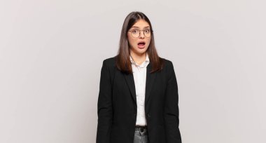 Genç iş kadını korkmuş ve şok olmuş hissediyor, ağzı açık şaşkınlık içinde.