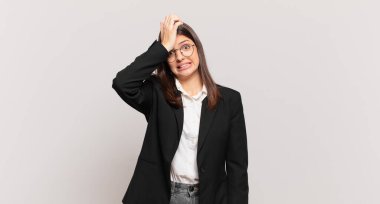 young business woman raising palm to forehead thinking oops, after making a stupid mistake or remembering, feeling dumb