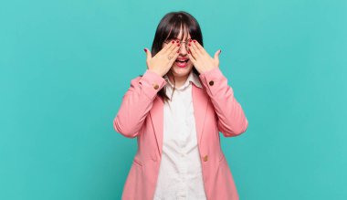 Genç iş kadını gülümsüyor ve mutlu hissediyor, iki eliyle gözlerini kapatıyor ve inanılmaz bir sürpriz bekliyor.