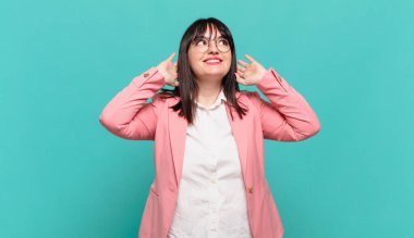 Genç iş kadını gülümsüyor ve rahatlıyor, tatmin oluyor, kaygısız, neşeli ve rahatlatıcı.