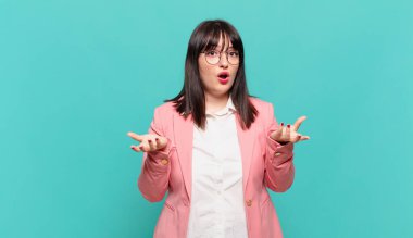 Genç iş kadını şok olmuş ve şaşırmış, endişeli ve paniklemiş hissediyor, stresli ve dehşete kapılmış bir bakışla