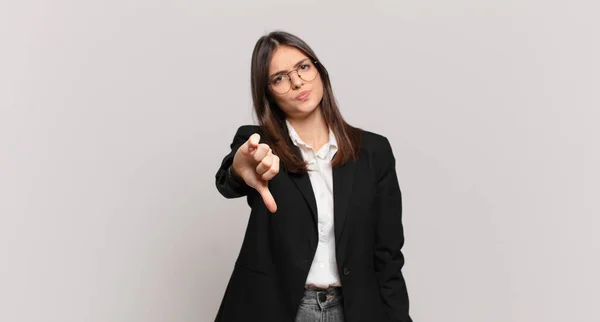 若いビジネスの女性は いらいら 失望または不満を感じ 深刻な表情で親指を下に示す — ストック写真