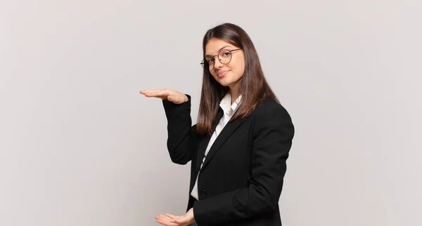 Młoda Kobieta Biznesu Trzymająca Przedmiot Obiema Rękami Boku Pokazująca Oferująca — Zdjęcie stockowe