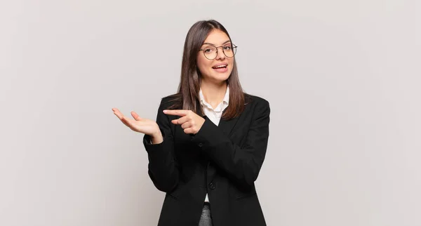 Junge Geschäftsfrau Lächelt Fröhlich Und Zeigt Auf Den Kopierraum Auf — Stockfoto