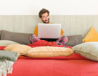 Genç sakallı adam komik bir şakaya gülüyor, mutlu ve neşeli hissediyor, eğleniyor.